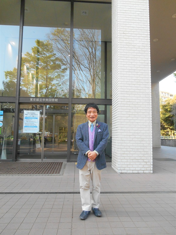 尾木名誉館長が都立中央図書館の入り口に立っている様子です。