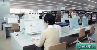 図書館内のパソコンを操作している女性の写真